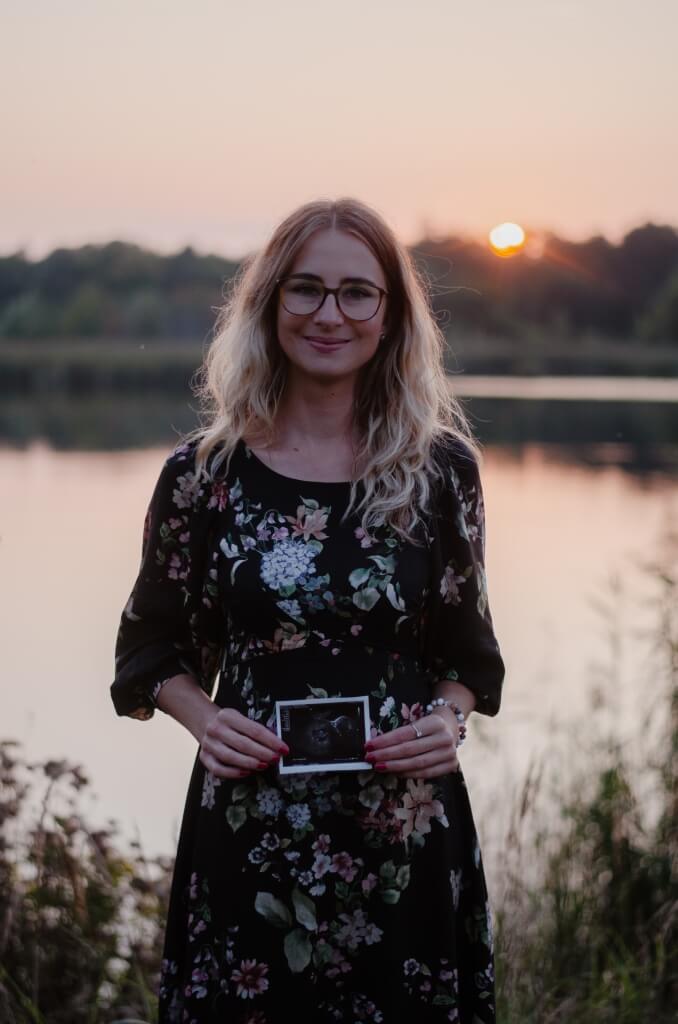 Meżczyzna, który obejmuje brzuch kobiety i wspólnie cieszą sie z nowego członka rodziny.